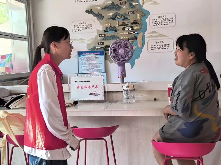 圖為花椒特產(chǎn)店店員向成員介紹花椒加工與合作的情況